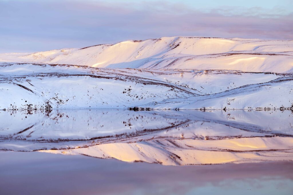 Snowy hills reflected in Kleifarvatn during winter conditions on the Reykjanes Peninsula.