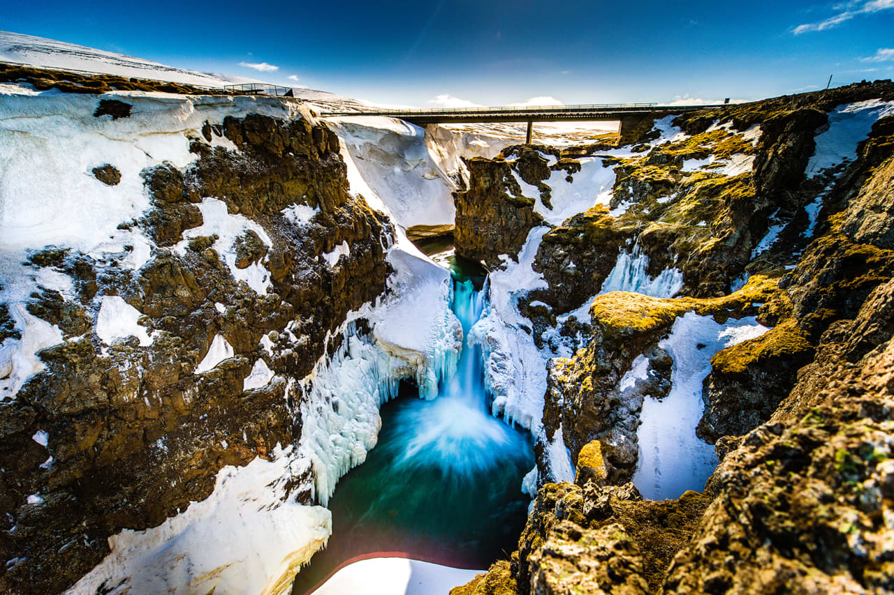 Winter snow and a bridge above the Kolugljúfur canyon in North Iceland.