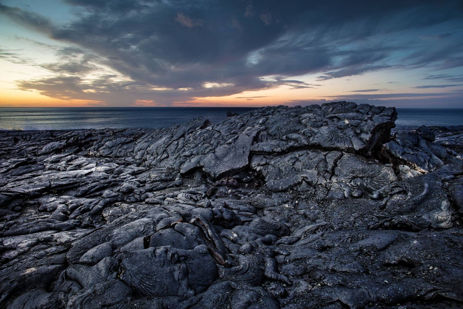 Black lava field in the Krafla volcanic area with low hills in North Iceland.
