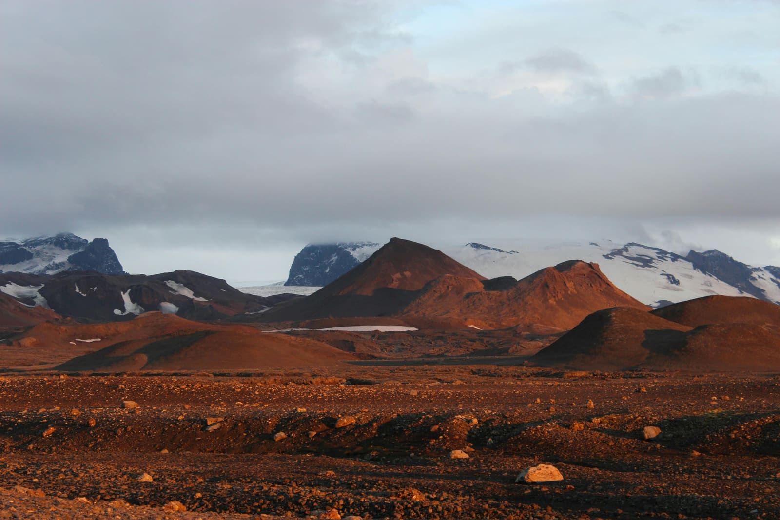 Kverkfjöll volcanic mountains and glacier ice lit by low sun above dark highland terrain.