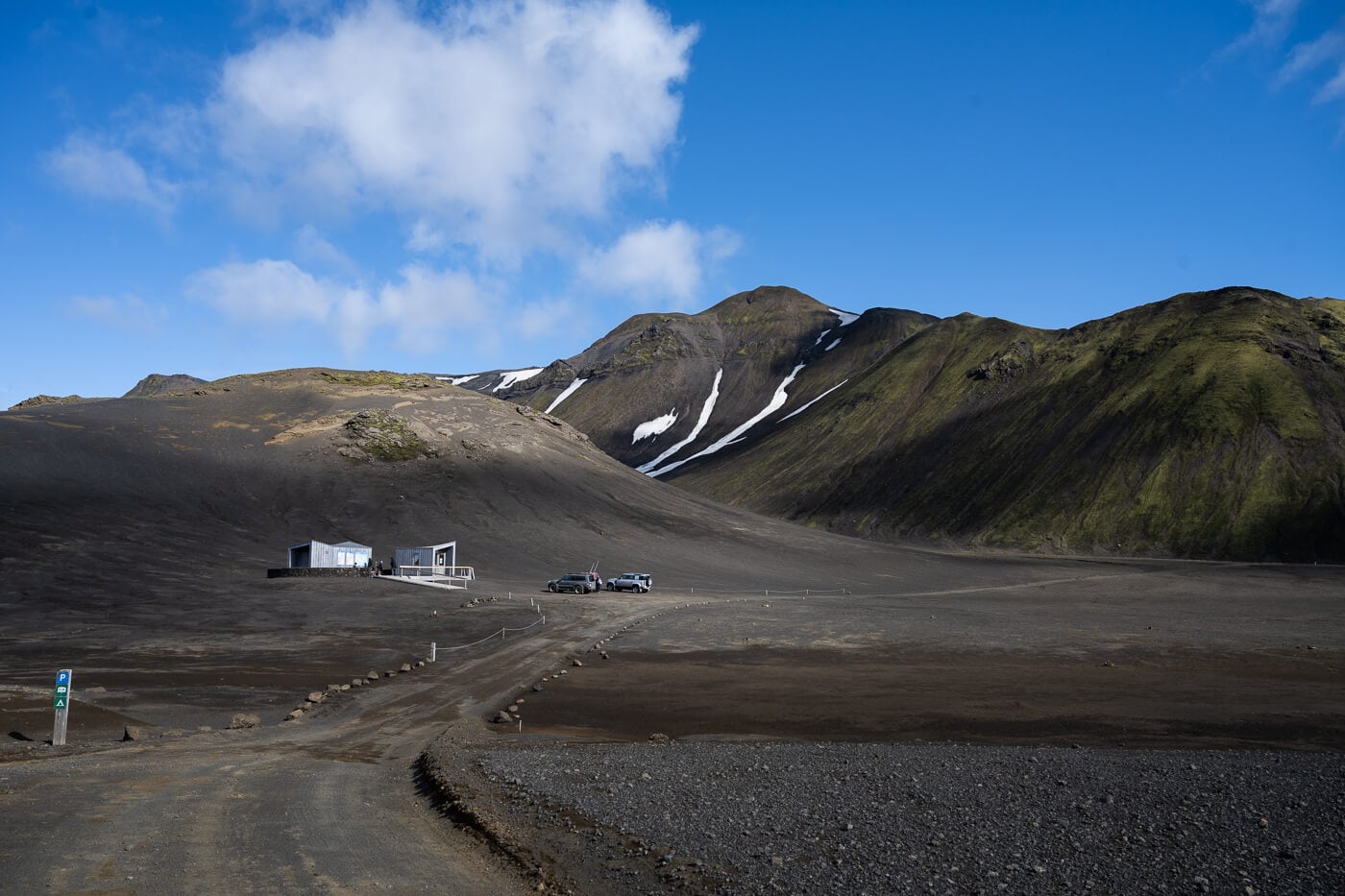 Langisjór information point and rough track below dark Highlands slopes near Sveinstindur.
