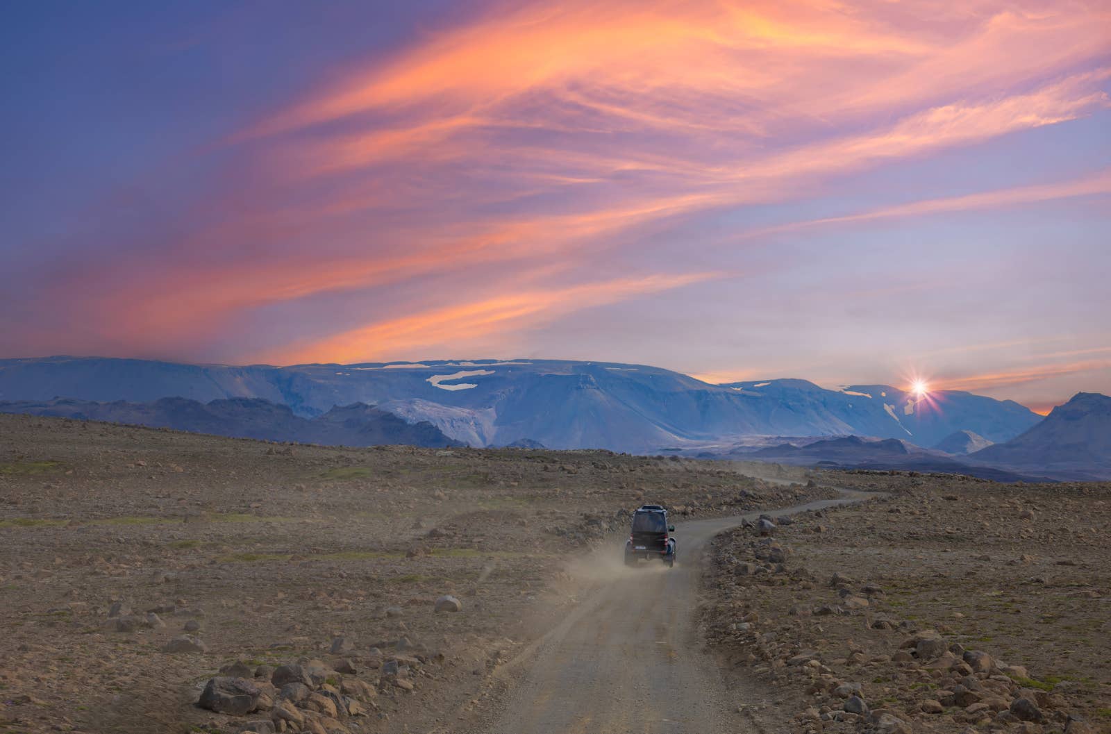 A vehicle driving across a highland track toward Langjökull glacier in Iceland.
