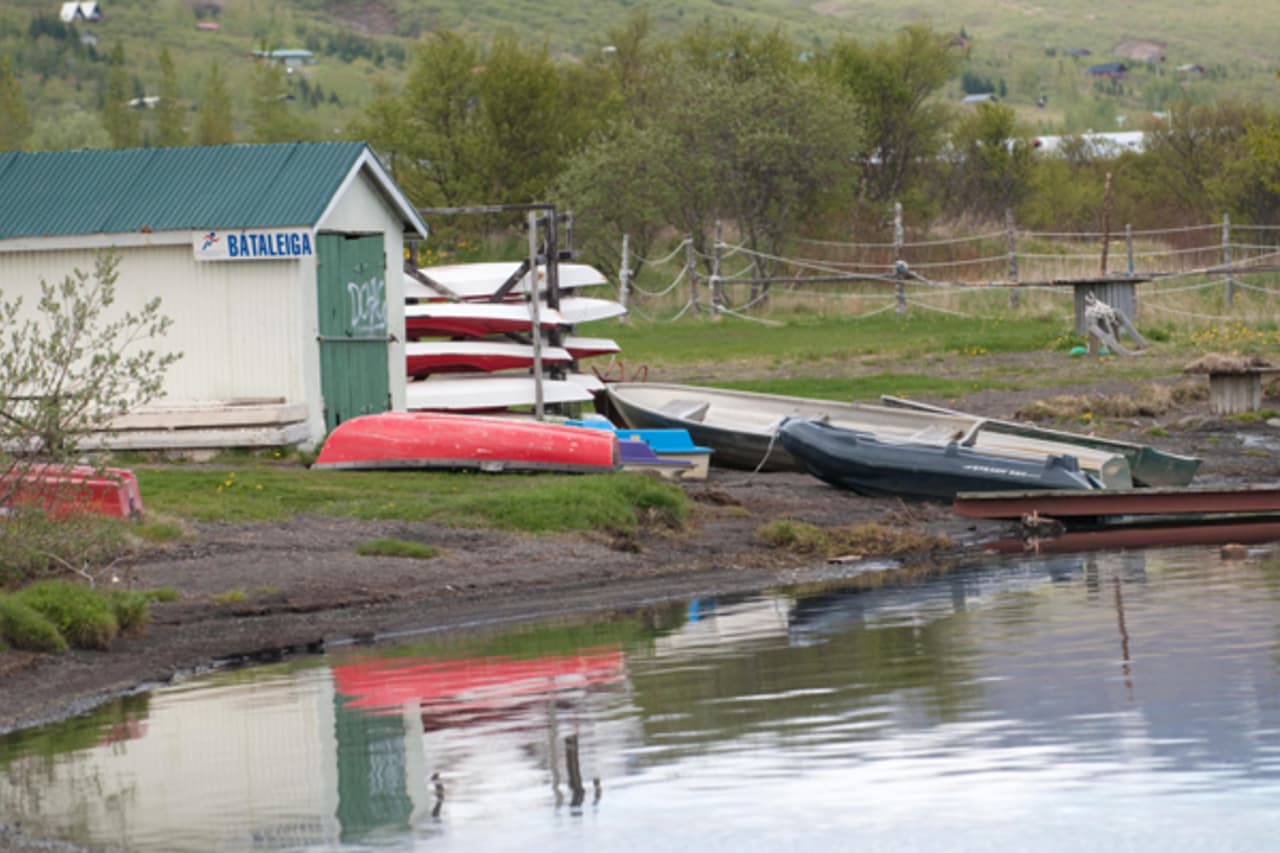 Small boats and canoes pulled up on the shore of Lake Laugarvatn beside the village.