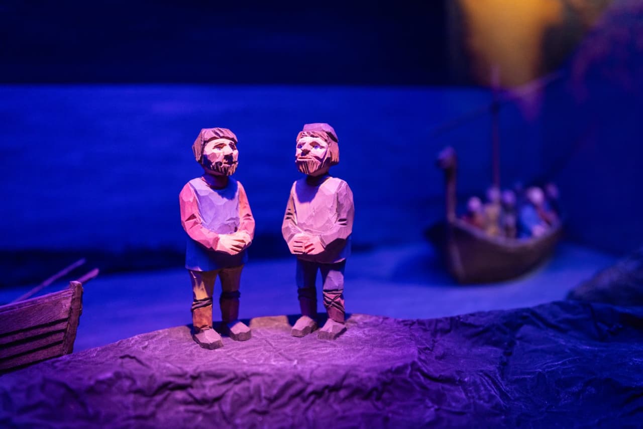 Carved figures and a small boat scene inside the Leifsbúð Vínland exhibition.