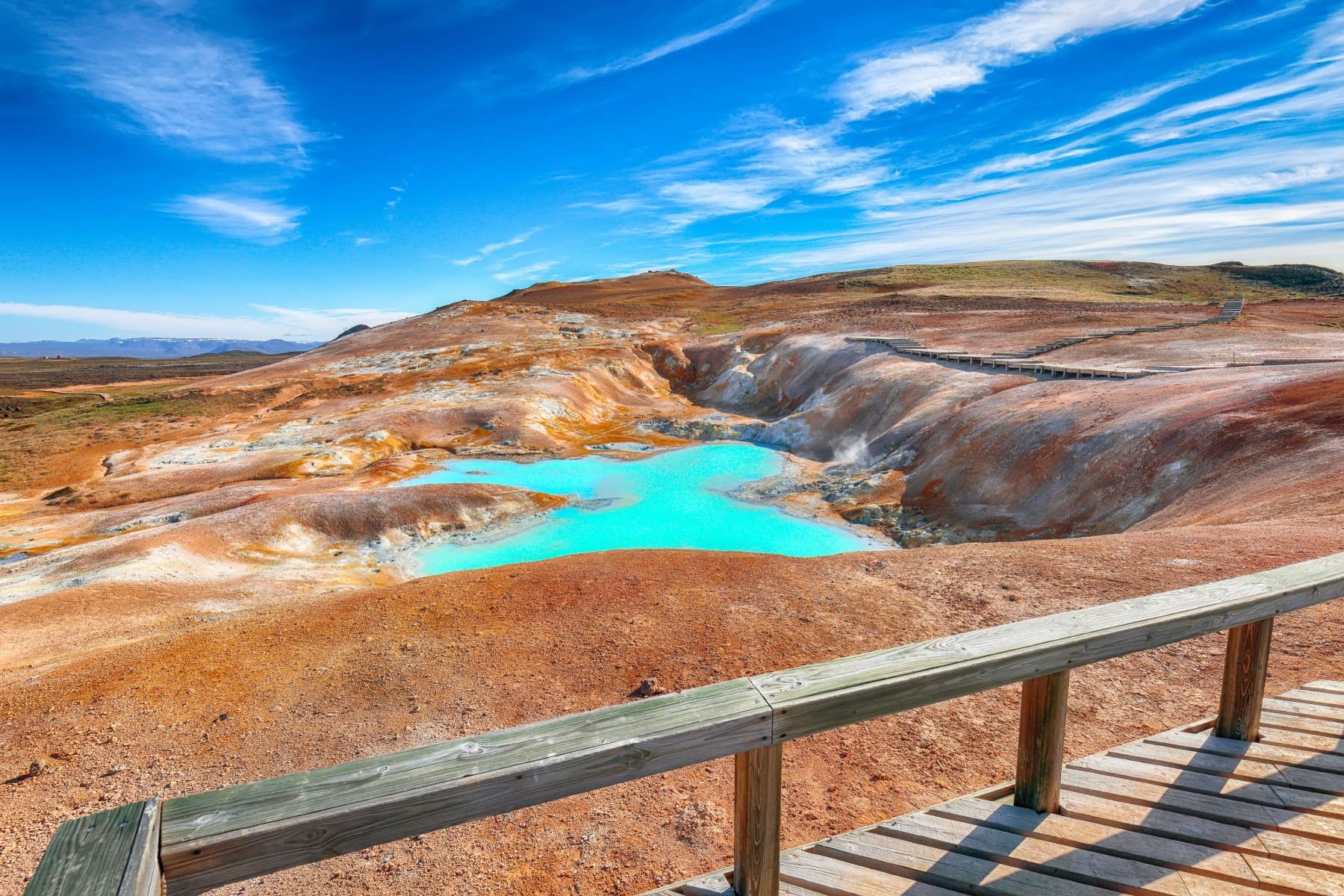 Bright geothermal pool and mineral-stained ground beside the marked Leirhnjúkur boardwalk.