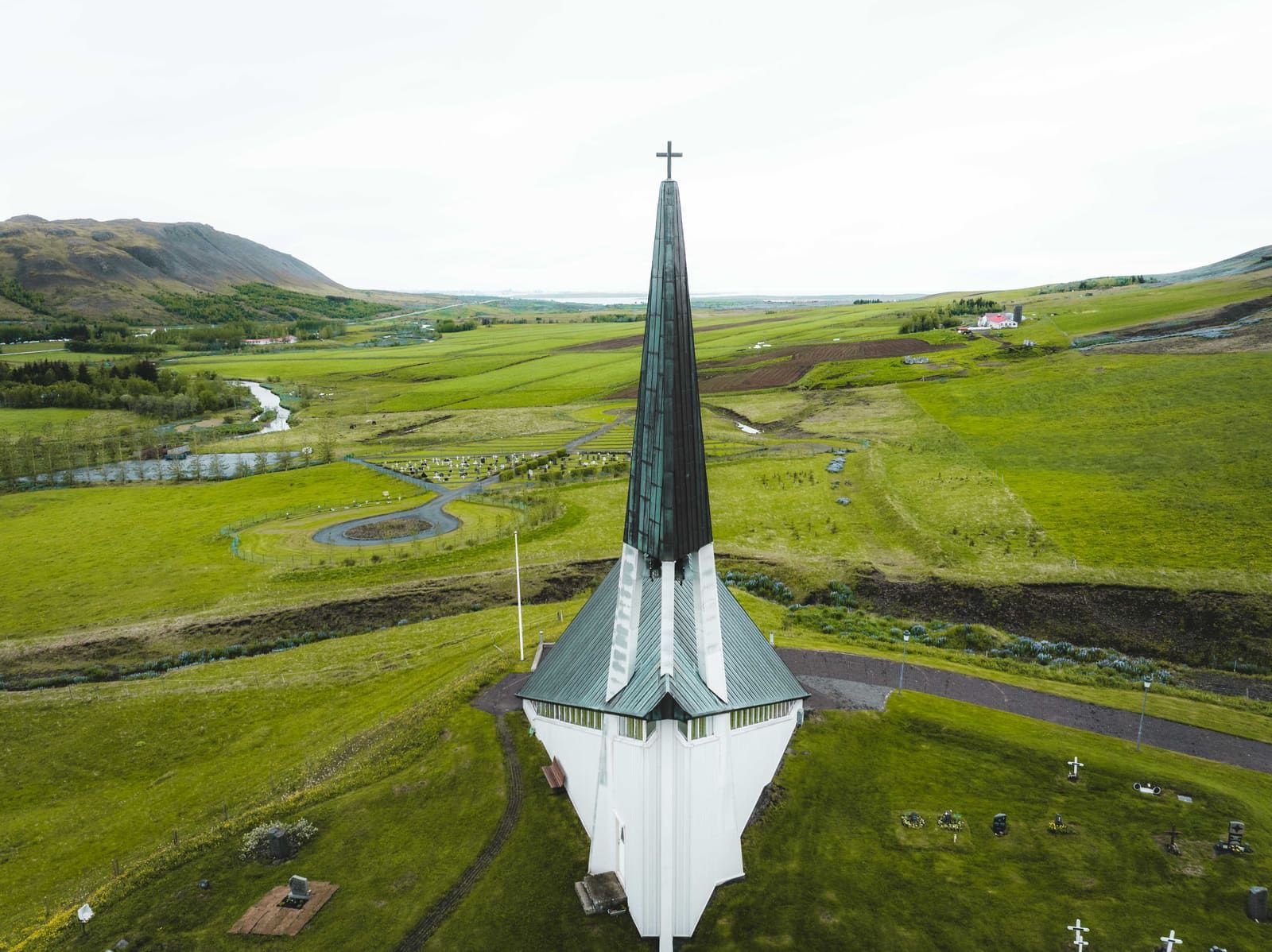 Mosfellskirkja above green fields and the Mosfellsdalur valley.