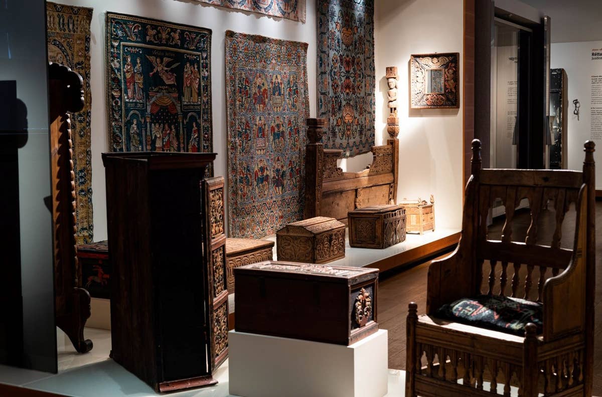 Carved wooden furniture and textile displays inside the National Museum of Iceland.