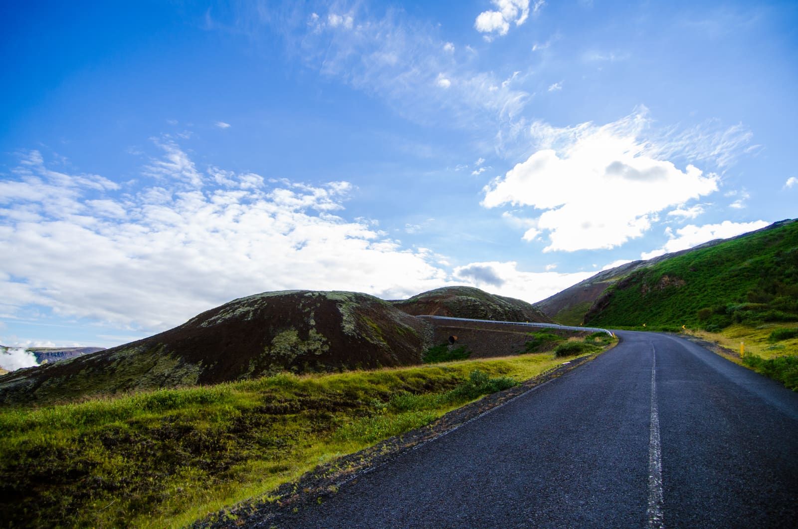 Road 435 curving through green and dark hills near Nesjavellir.