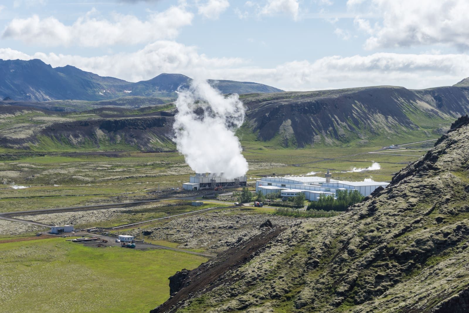 Nesjavellir power station seen from a rocky hiking trail above the geothermal landscape.