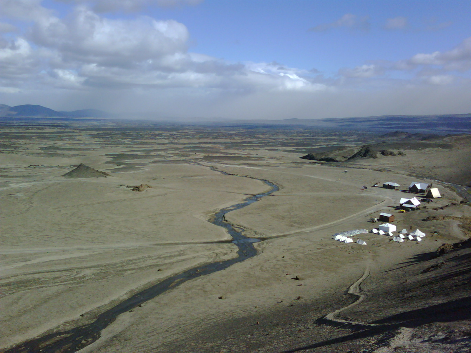 Ódáðahraun lava desert seen from Askja with huts, a stream, and wide highland plains below.