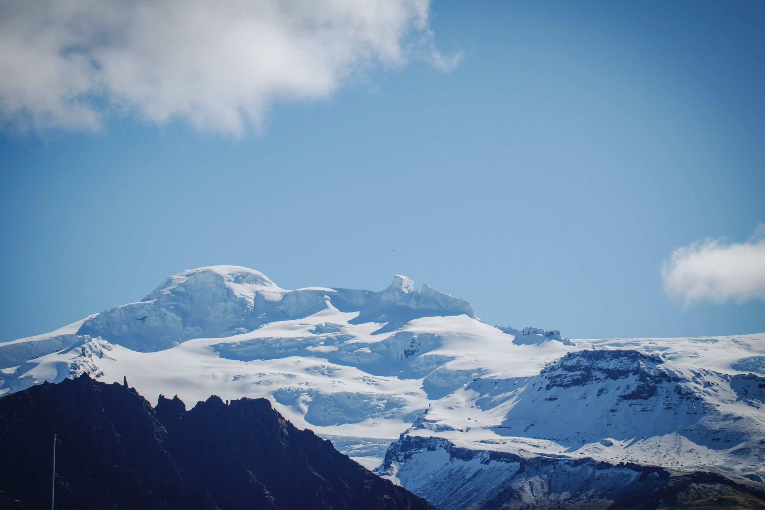 Öræfajökull ice cap and Hvannadalshnúkur above dark ridges in southeast Iceland.