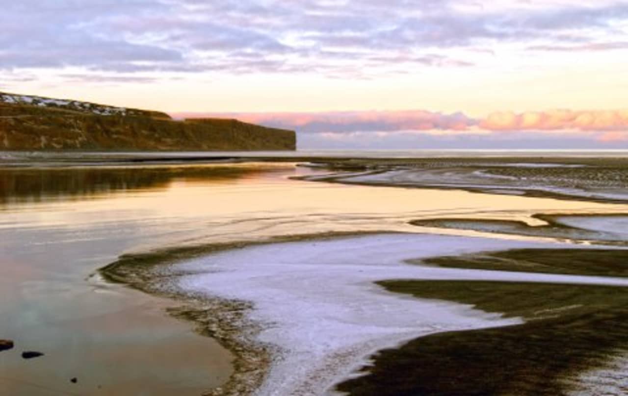 Black-sand shoreline and calm water near Fjallahöfn by Öxarfjörður.