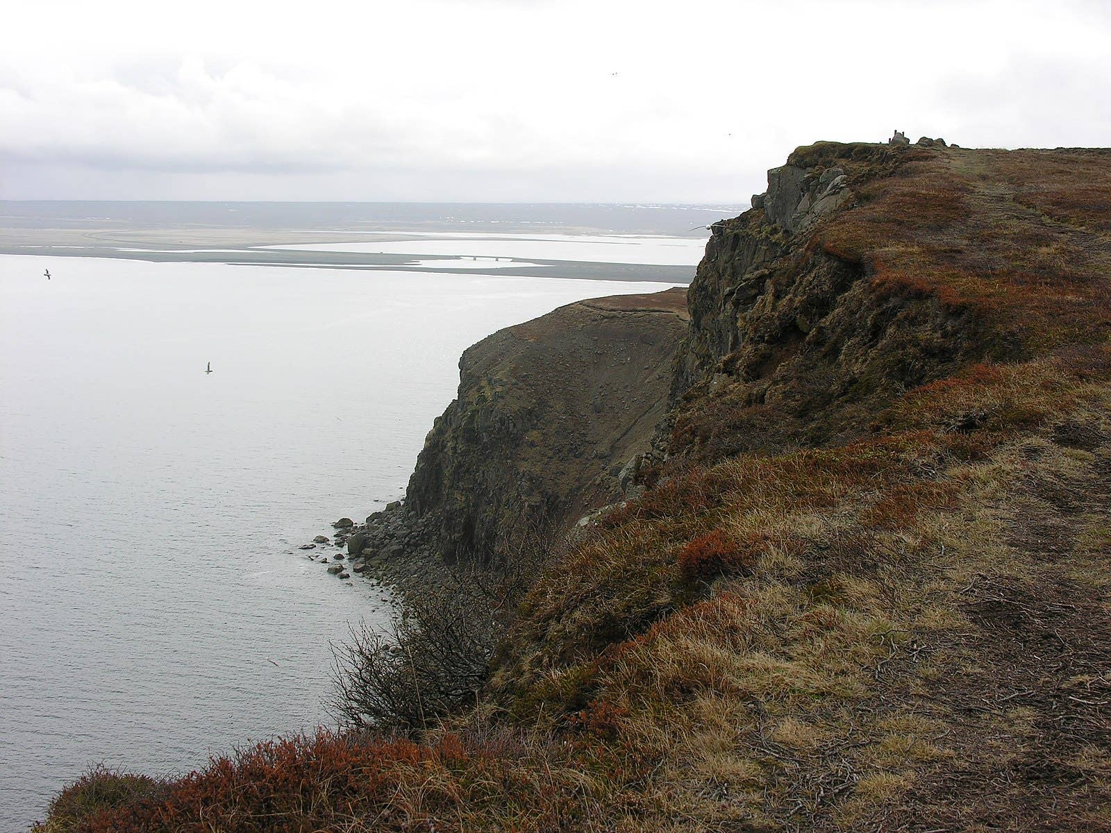 Remote coastal landscape in Öxarfjörður with water, low hills, and rural shoreline.