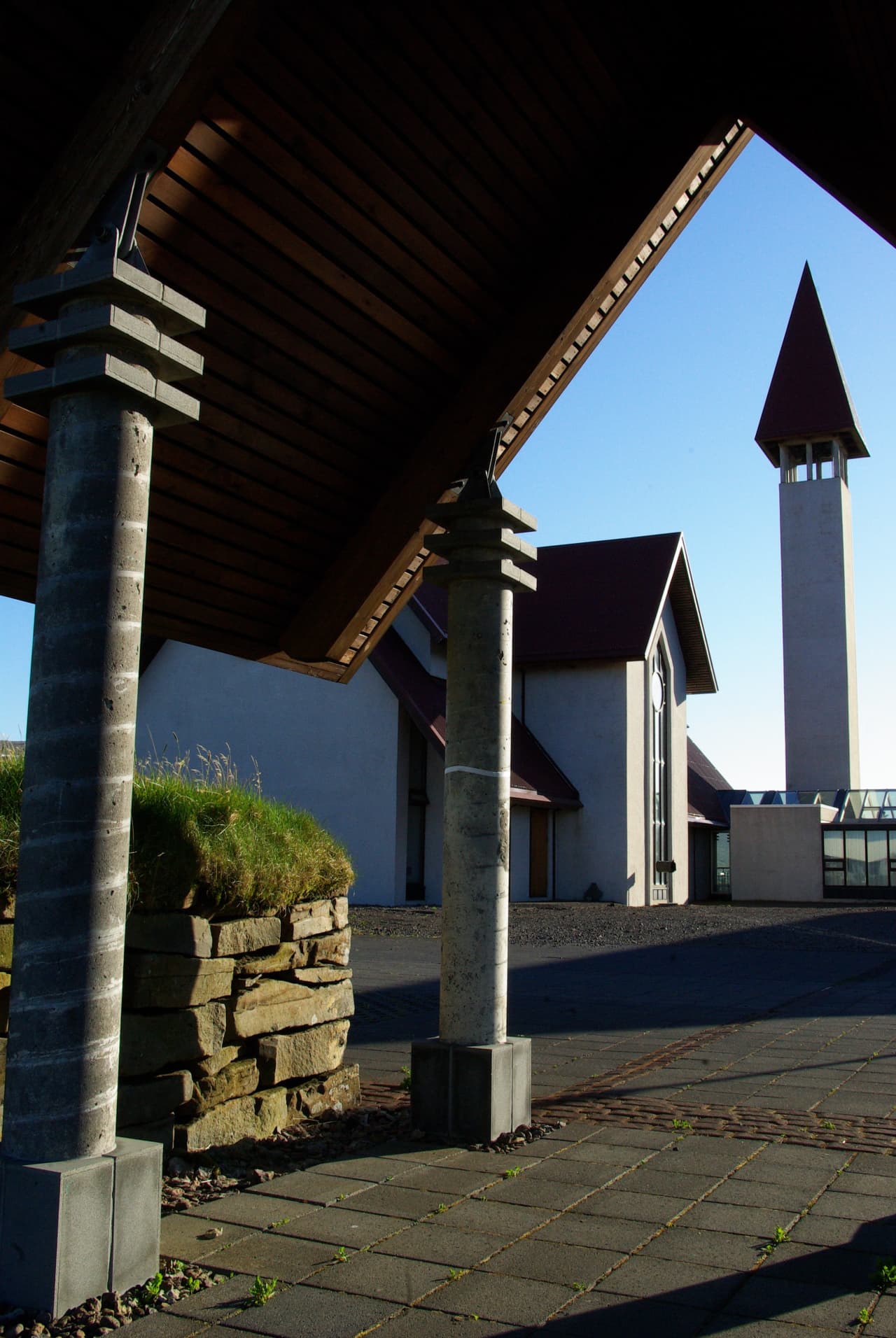 Reykholt church tower seen past turf and stone details near Snorrastofa