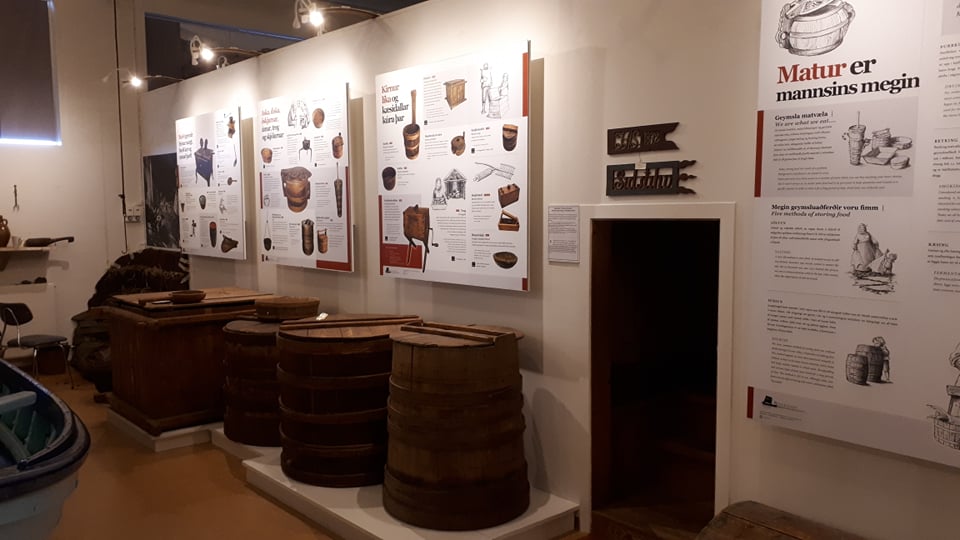 Food-history panels, barrels, and storage objects inside Reykir Regional Museum.