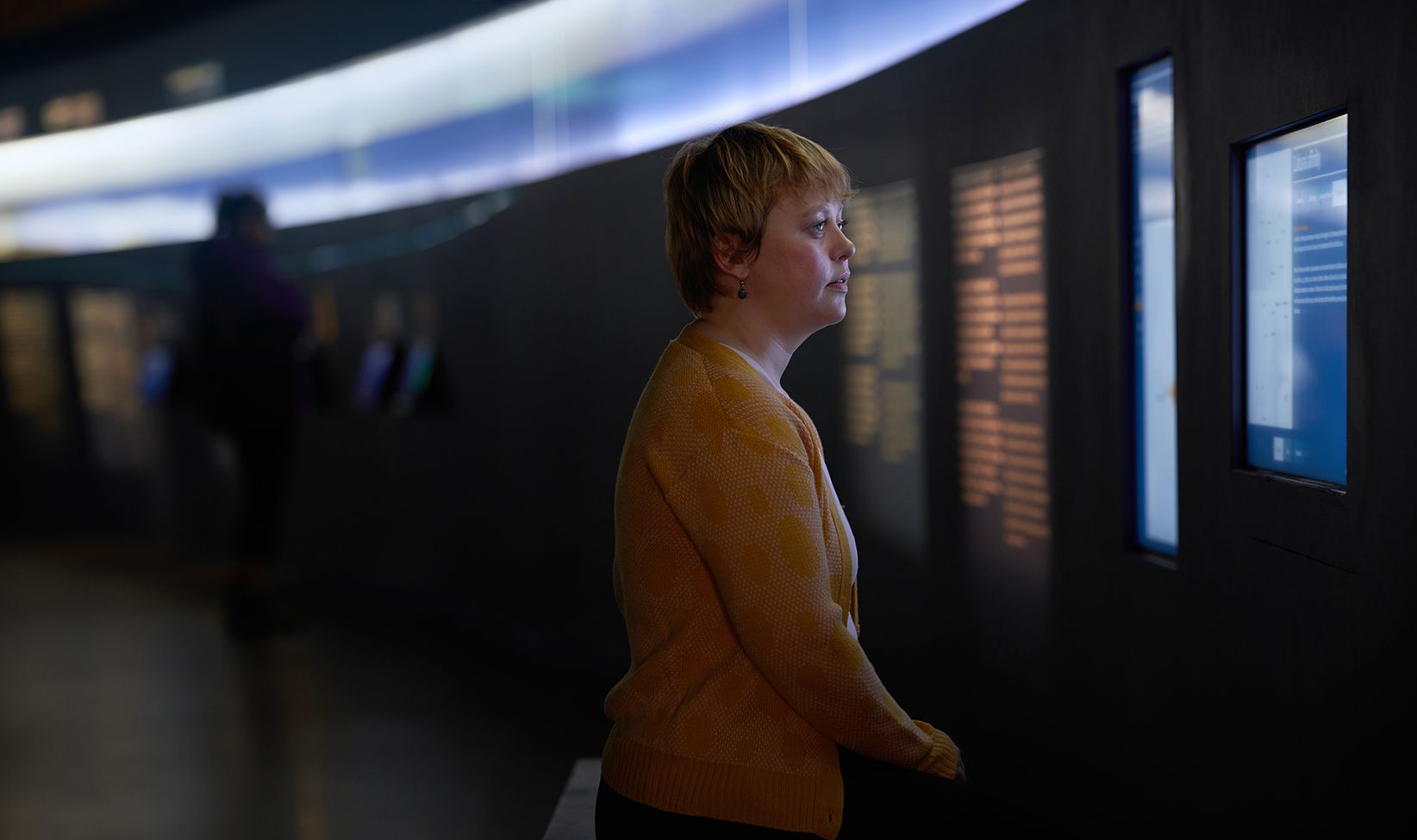 Visitor reading digital displays inside the Aðalstræti Settlement Exhibition in Reykjavík.