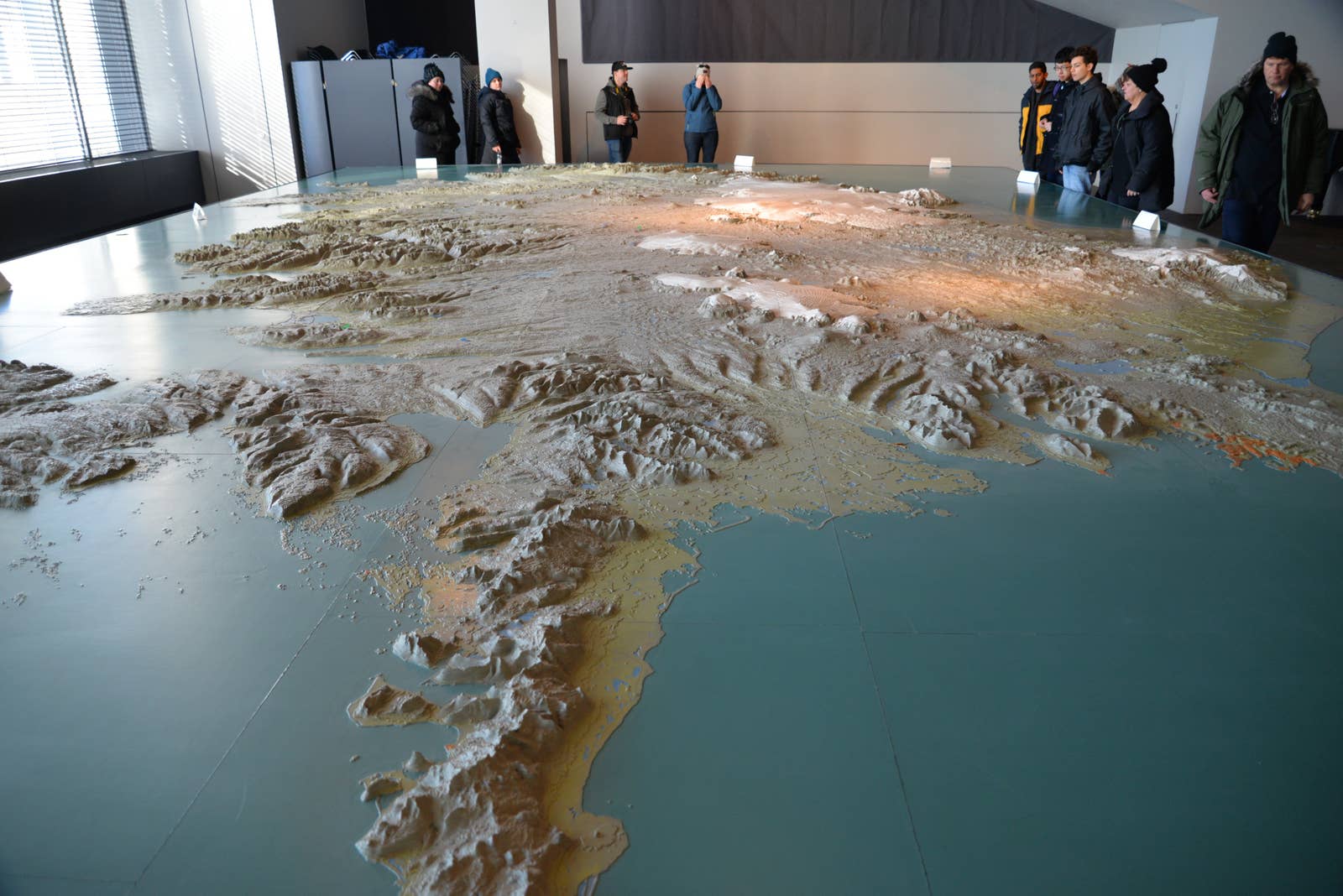 Large 3D Iceland relief map inside Reykjavík City Hall with visitors around the display