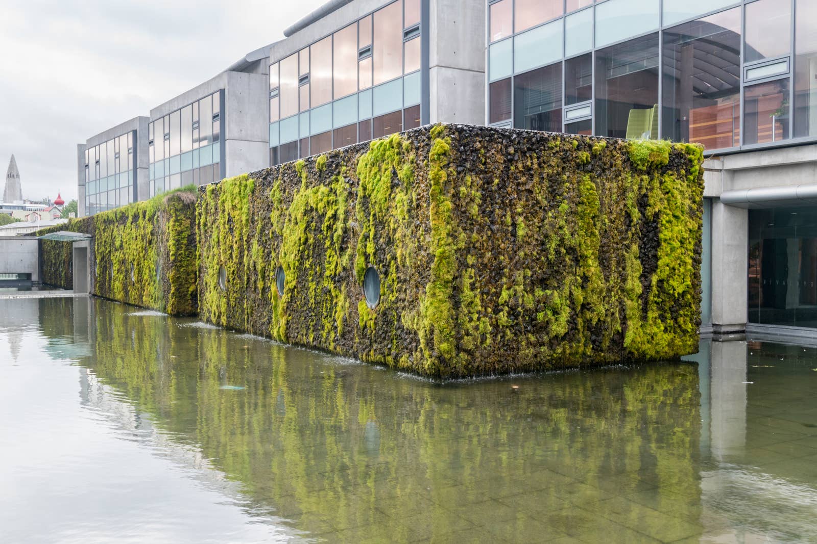 Moss-covered wall and water feature outside Reykjavík City Hall beside Tjörnin
