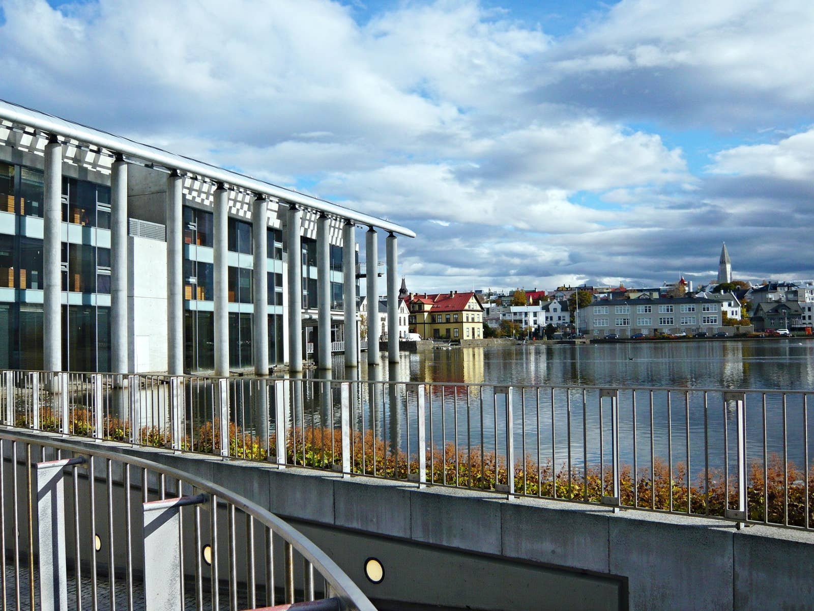 Reykjavík City Hall on the edge of Tjörnin with downtown buildings reflected in the water