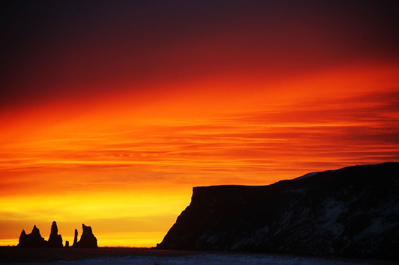 Reynisfjall ridge and Reynisdrangar sea stacks silhouetted from the Vík coast