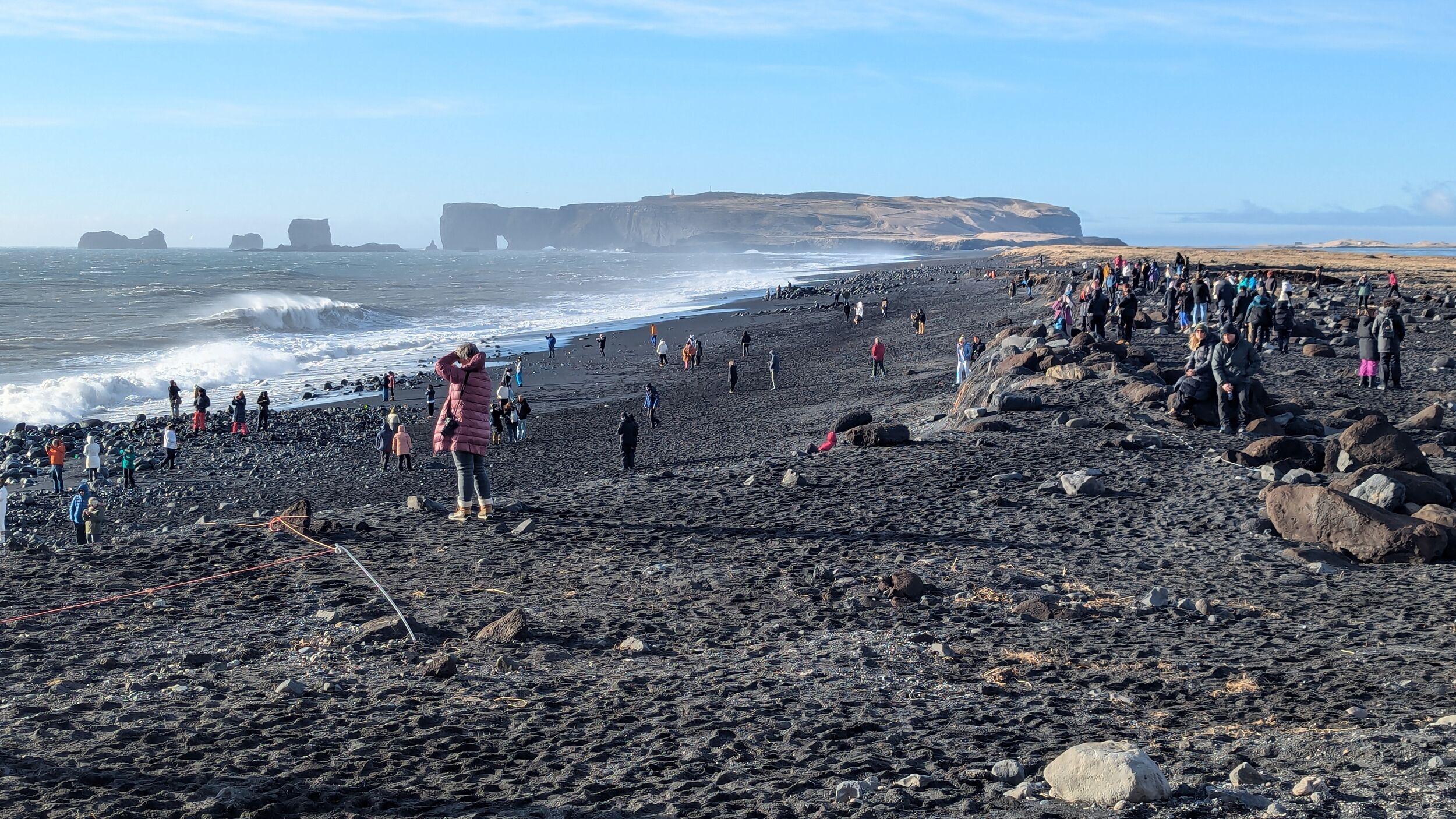 Visitors viewing Reynisfjara from the black sand and upper beach area after recent shoreline changes