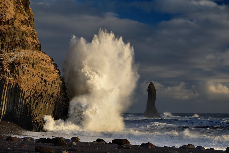 Large wave breaking beside the basalt cliffs at Reynisfjara black beach