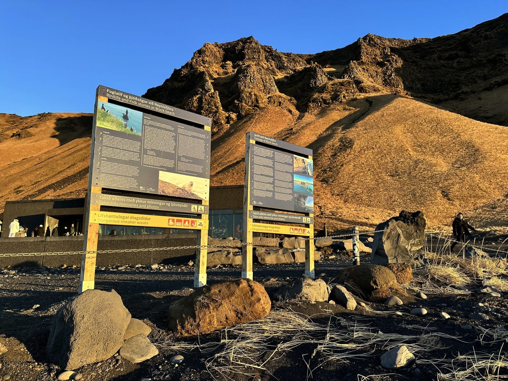 Warning and information signs at Reynisfjara black beach below Reynisfjall