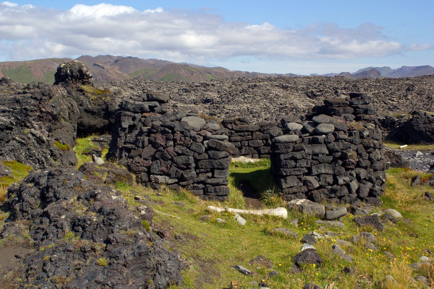Lava-stone ruin walls at Selatangar with Reykjanes mountains beyond the old fishing station.