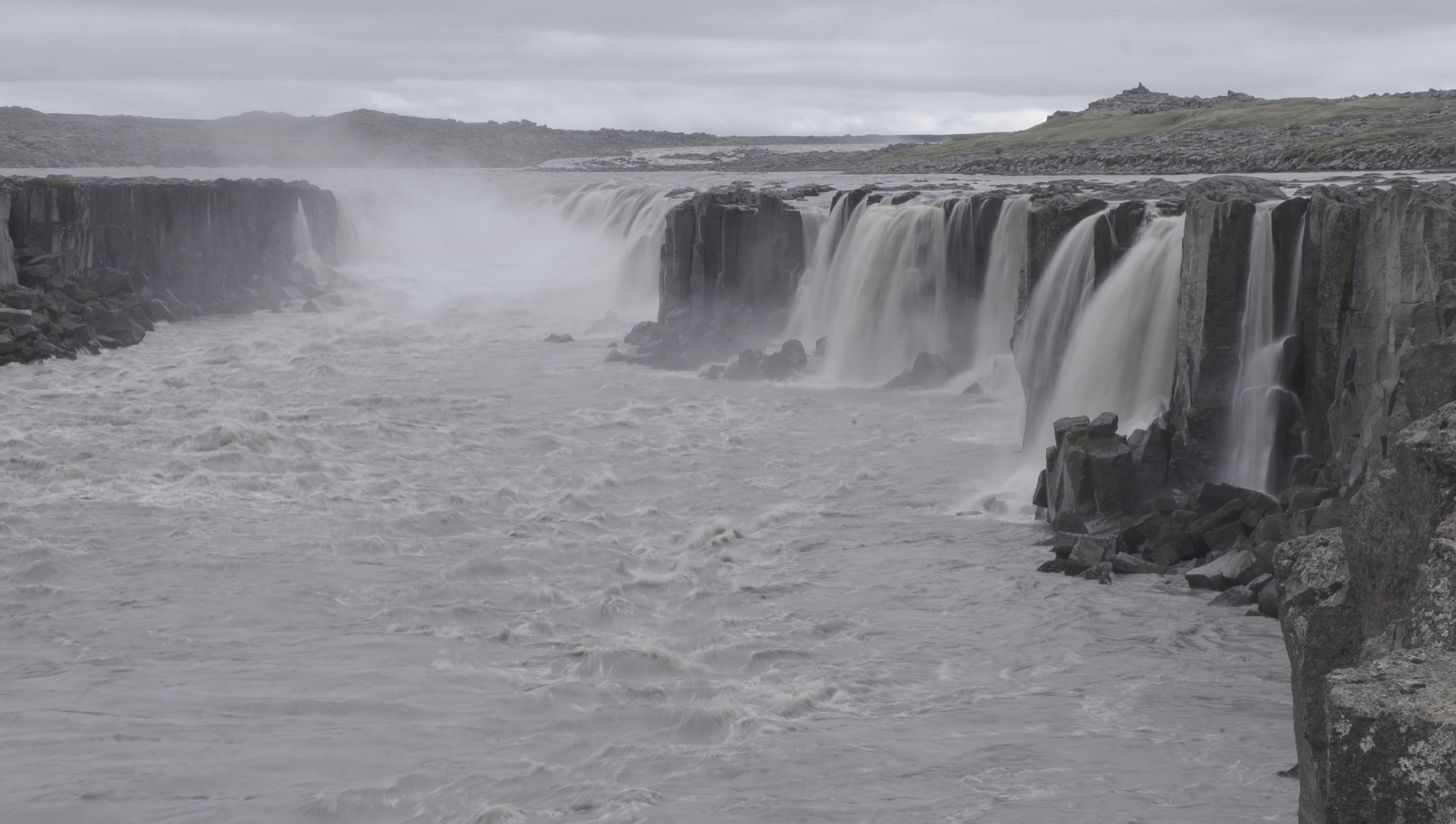 Mist drifting across Selfoss Waterfall on an overcast day in Jökulsárgljúfur canyon.