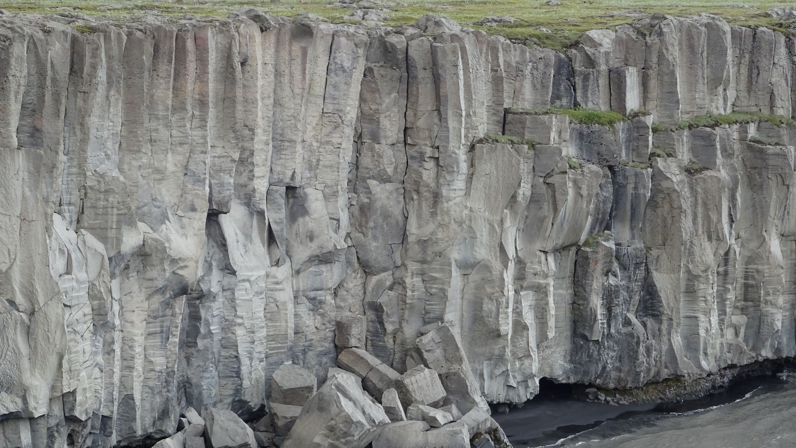 Basalt cliff detail beside the Selfoss Waterfall riverbank in North Iceland.