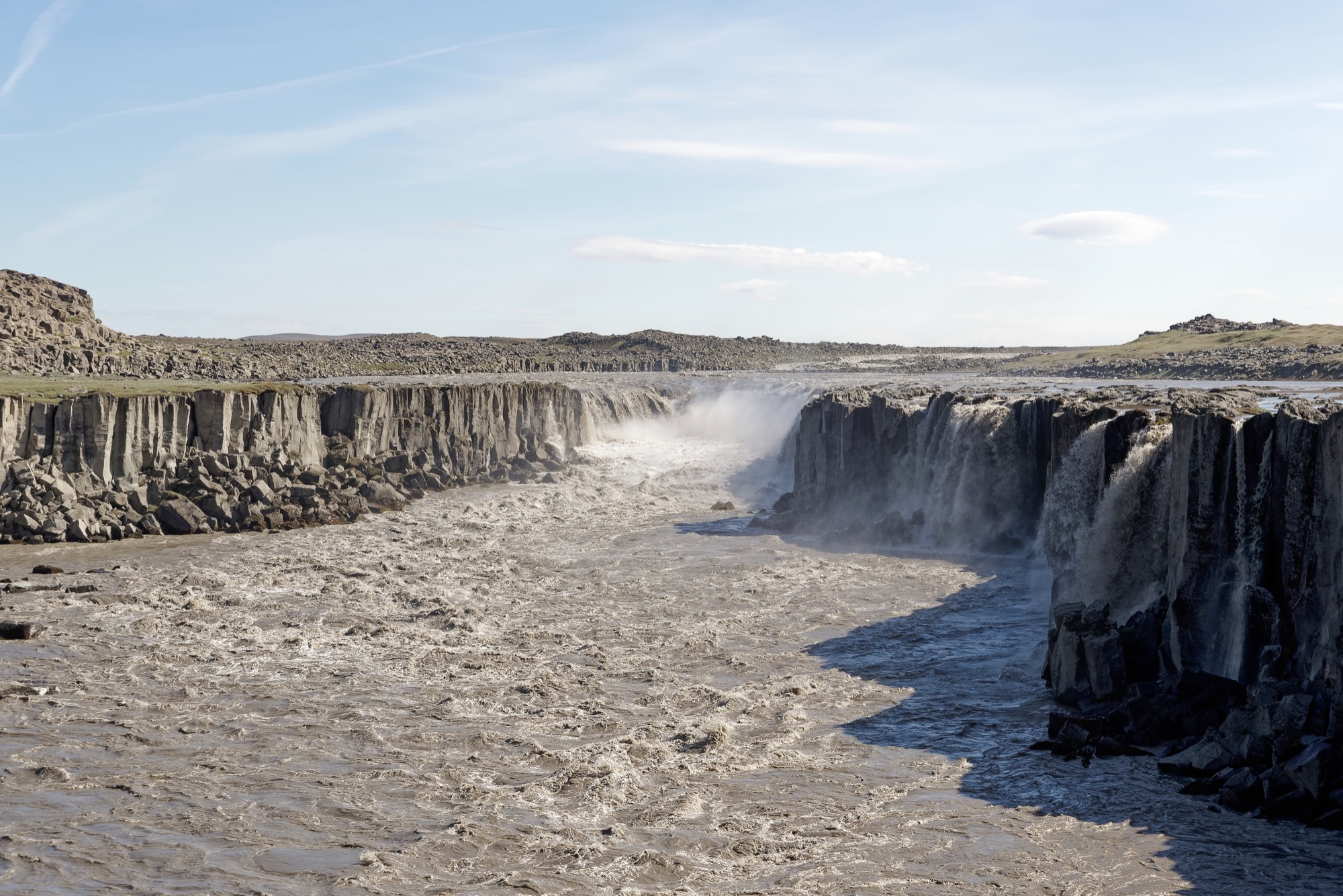 Spray rising from Selfoss Waterfall where Jökulsá á Fjöllum drops through a rocky canyon.
