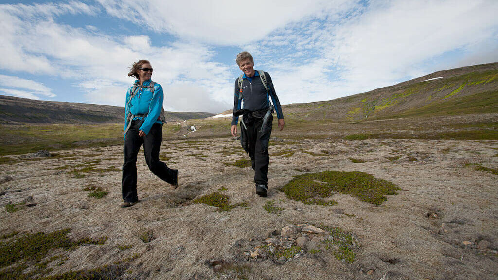 Hikers crossing open summer terrain on the Seljalandsdalur to Hnífsdalur route in the Westfjords.