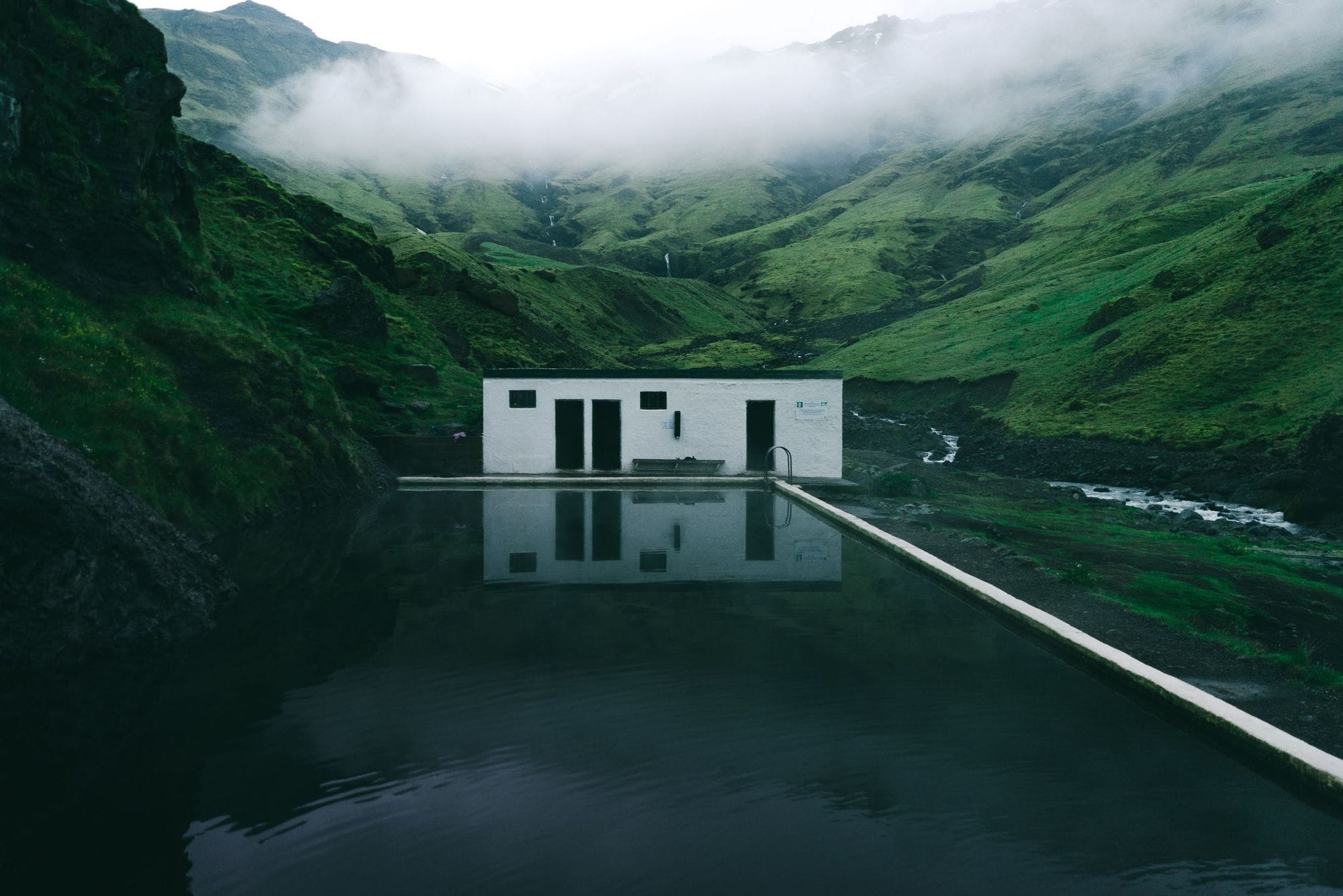 Seljavallalaug historic mountain pool in Seljavellir valley on Iceland’s South Coast.