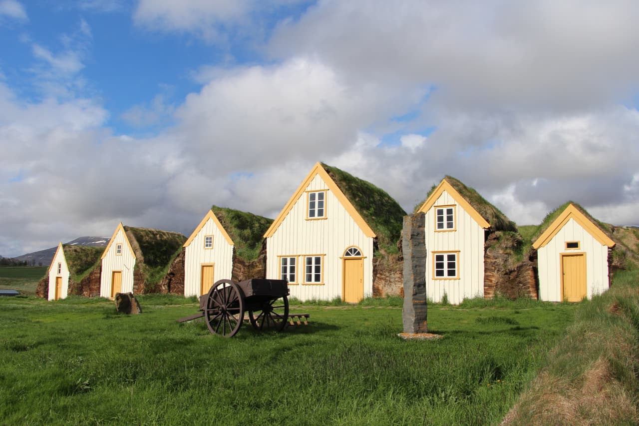 White-gabled turf buildings at Glaumbær in green Skagafjörður farmland.