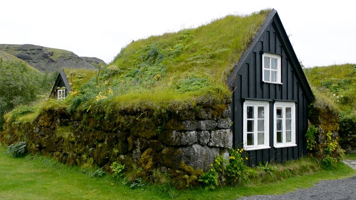 Close view of a black turf-roofed house in the open-air section of Skógar Museum.
