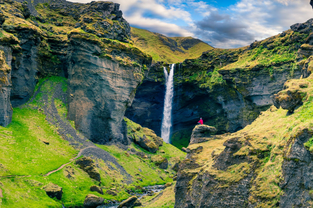 Kvernufoss framed by green canyon walls on a walking route near Skógar.