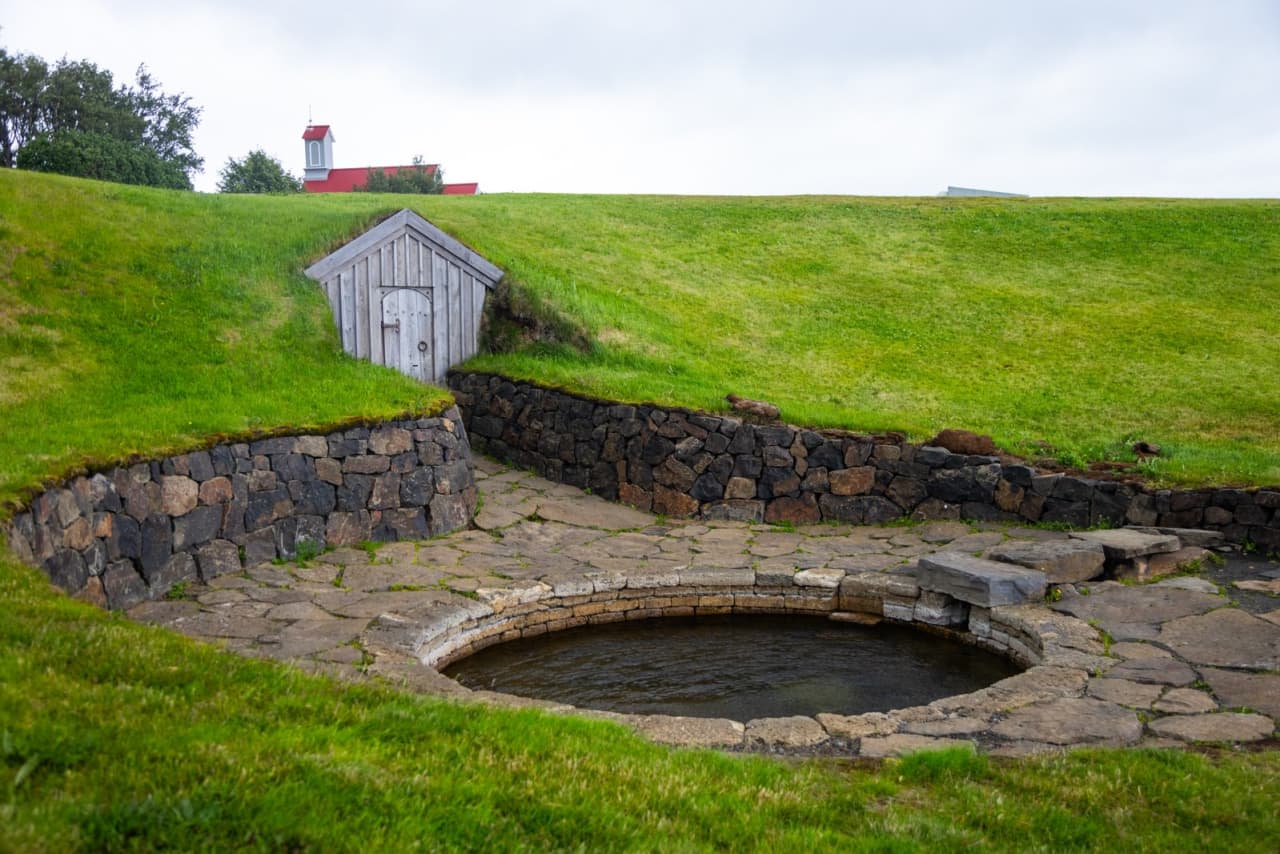 Snorralaug with its grassy slope and doorway in Reykholt, West Iceland.