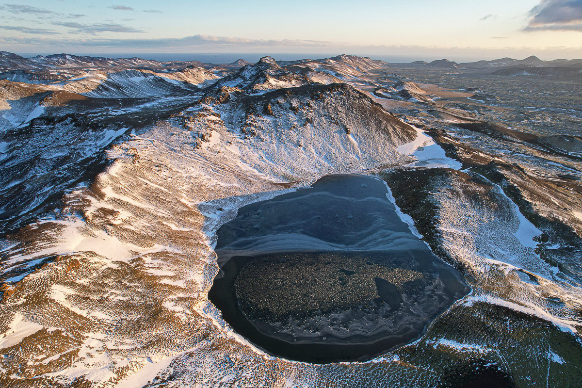 Snow around Spákonuvatn and the surrounding Reykjanes hills in winter light.