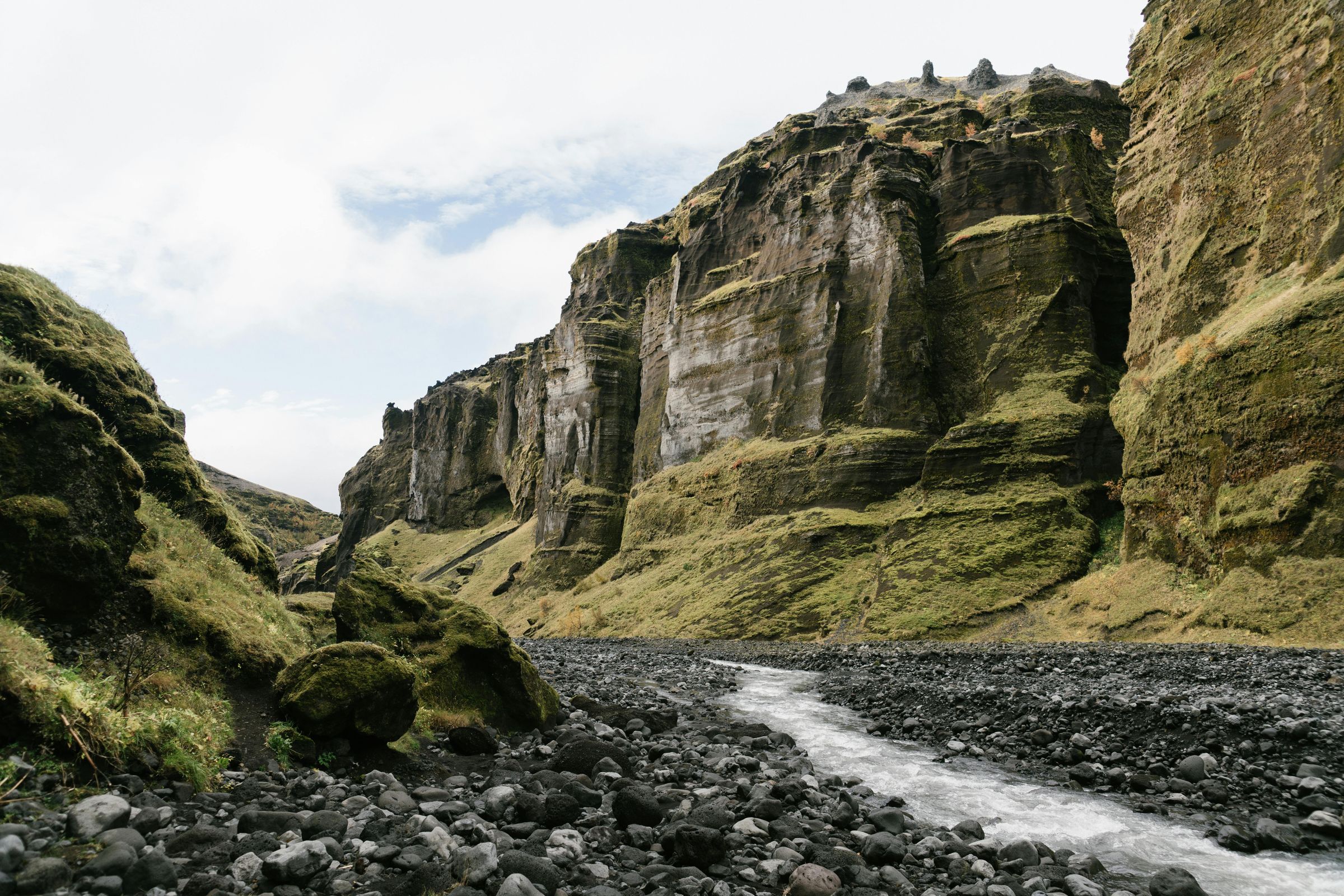 The rocky stream bed and layered canyon walls inside Stakkholtsgjá.