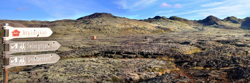 Trail signs and low lava hills on the approach toward Stóri-Bolli.