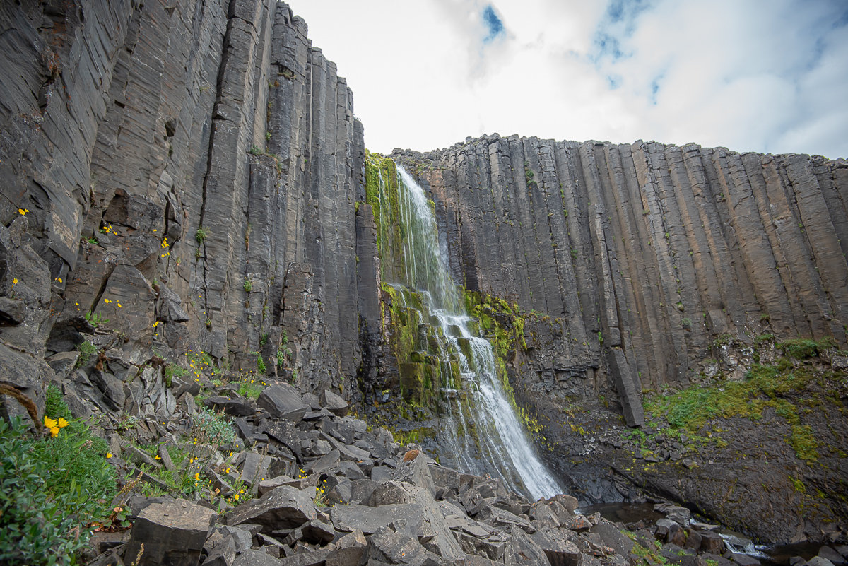 Stuðlafoss falling through a high wall of basalt columns in Jökuldalur, East Iceland.
