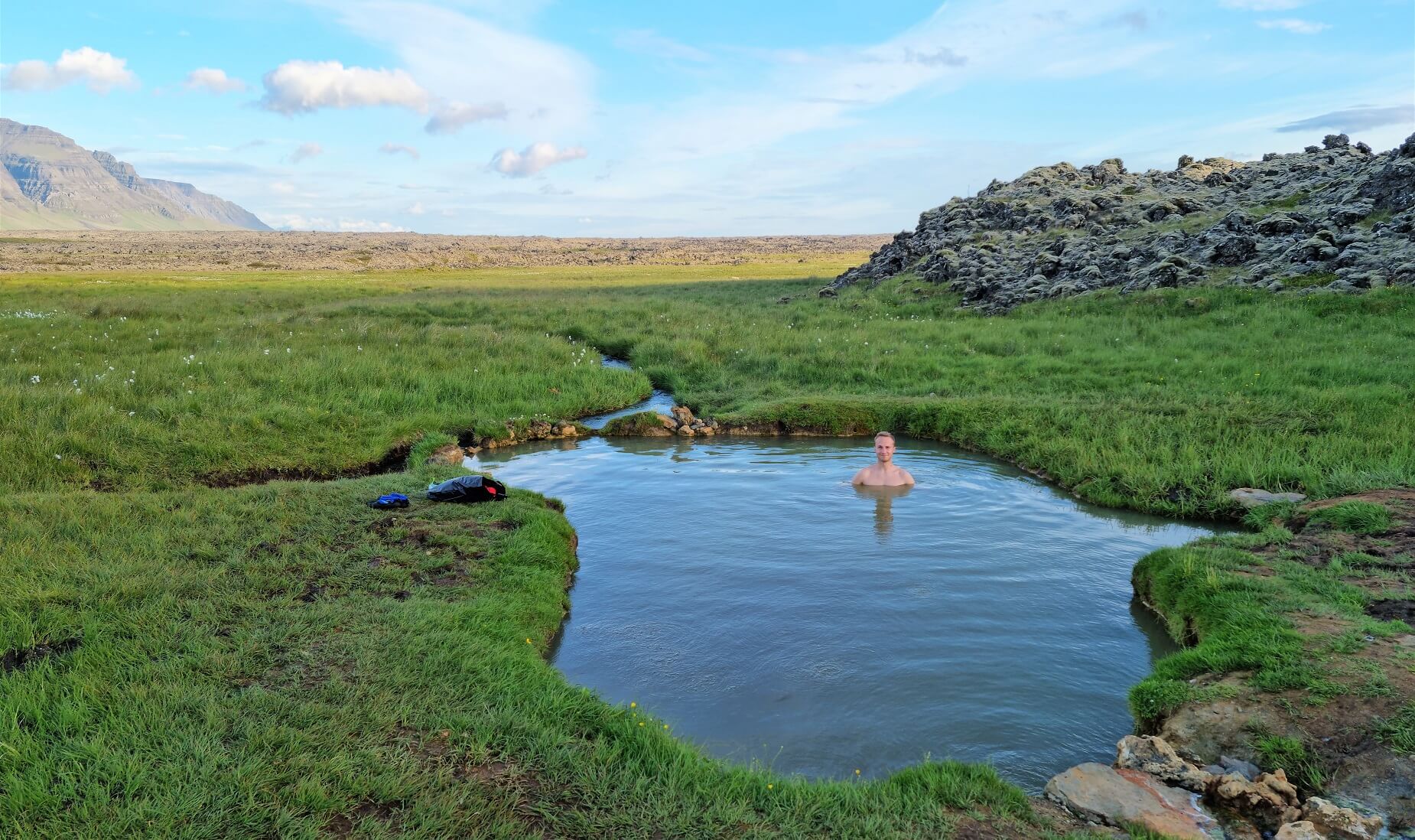 Sturlungalaug Hot Springs pool in grassy lava-country terrain on eastern Snæfellsnes.