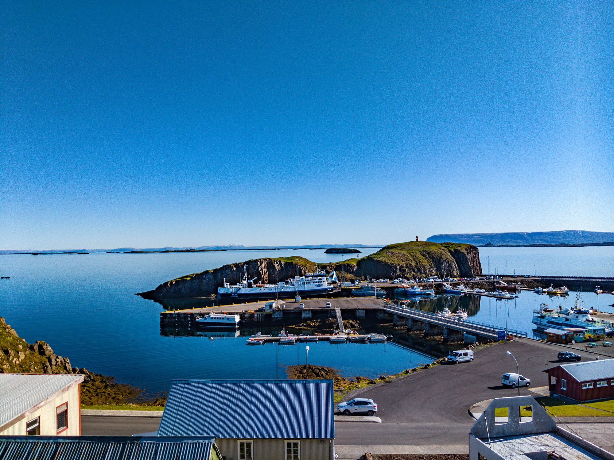 Stykkishólmur harbor, boats, and the Súgandisey cliff seen from above town.