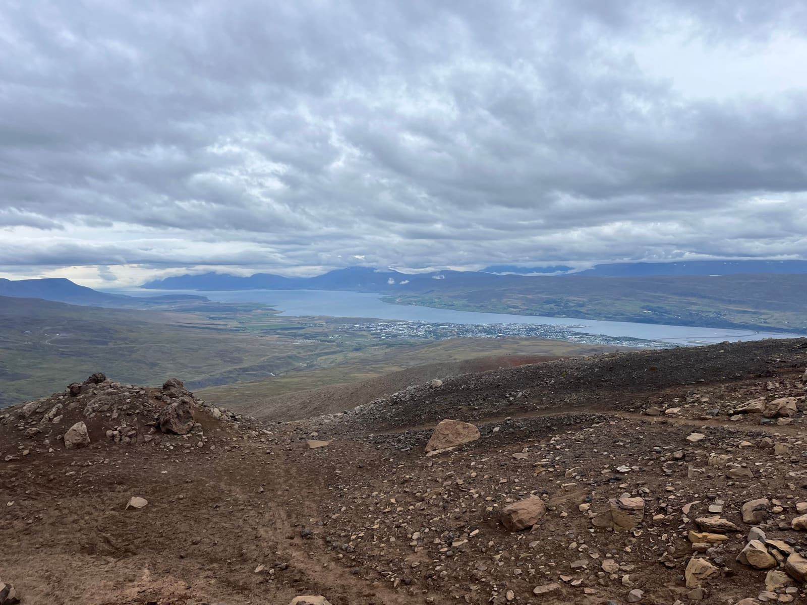 View from the Súlur route over Akureyri and Eyjafjörður under a cloudy sky.