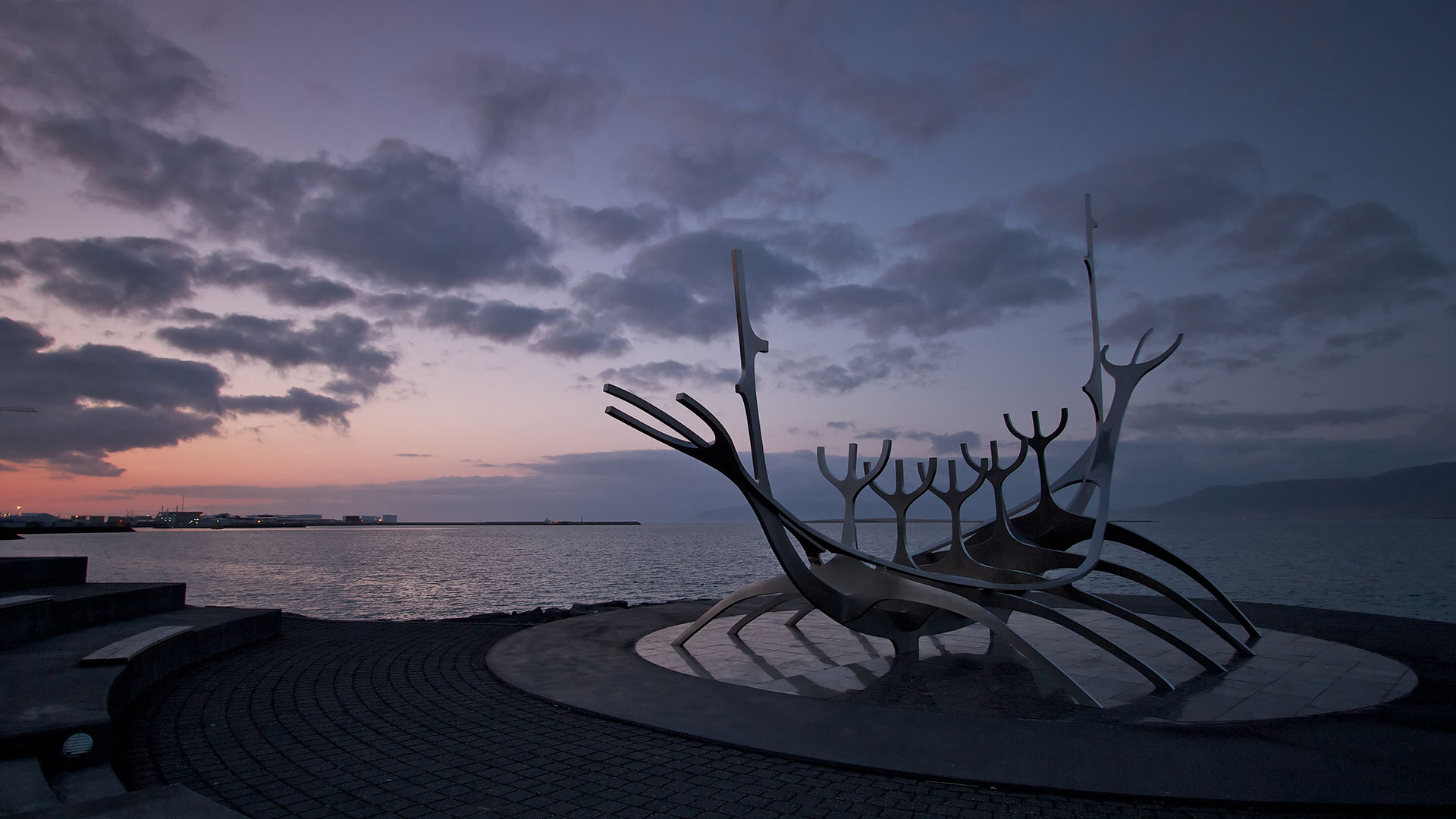 Sun Voyager sculpture beside Faxaflói bay and Mount Esja at dusk