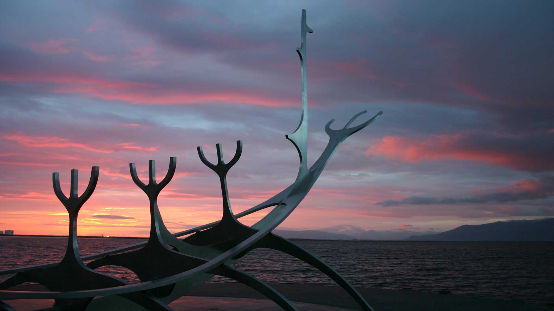 Close view of the Sun Voyager steel ribs against a pink Reykjavík sunset
