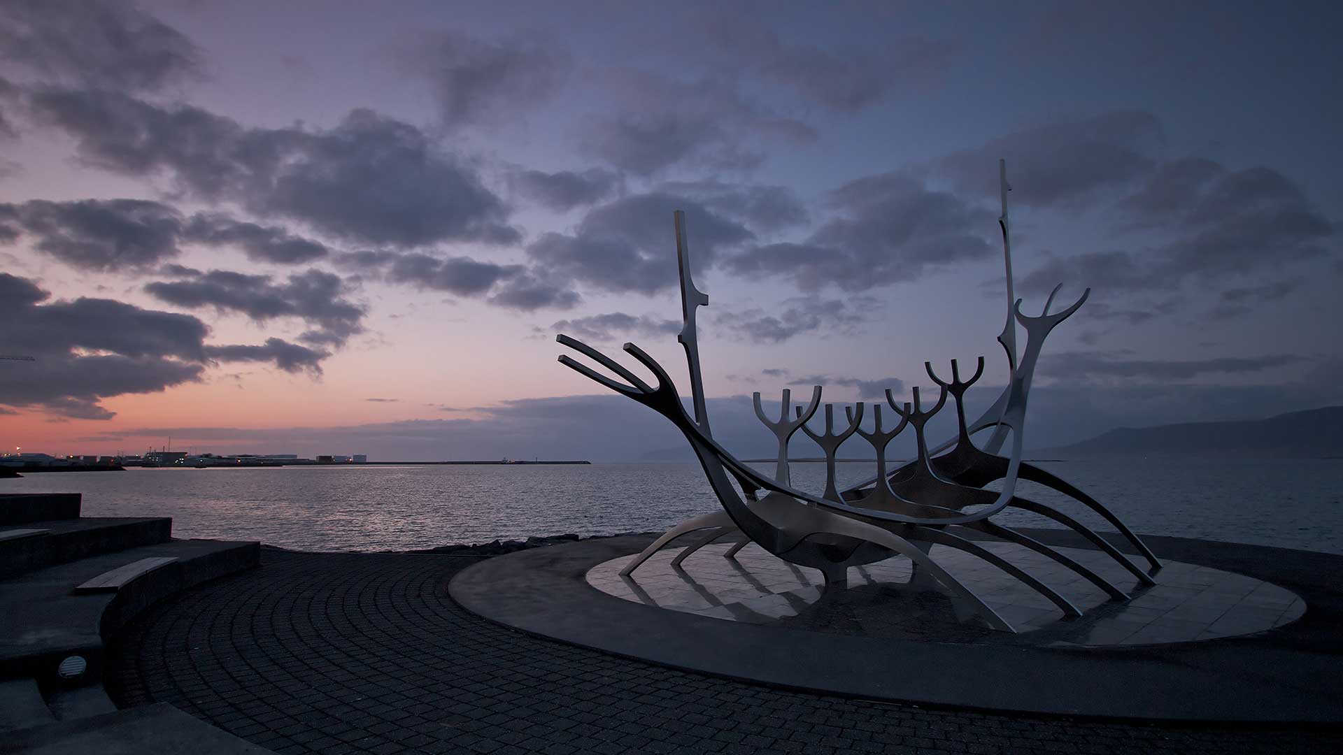 Sun Voyager sculpture on the Reykjavík waterfront at dusk with Faxaflói bay behind it