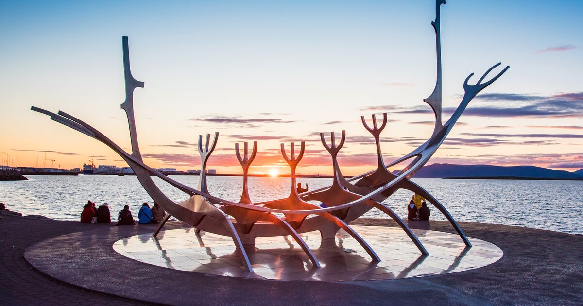 Visitors sitting around the Sun Voyager sculpture during sunset on the Reykjavík waterfront