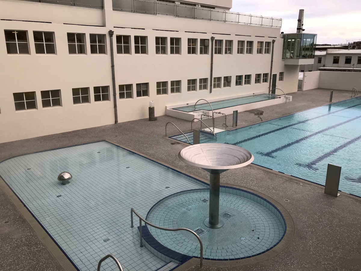 Overhead view of Sundhöllin’s outdoor layout with lap pool, upper tubs, and shallow pool areas in central Reykjavík.