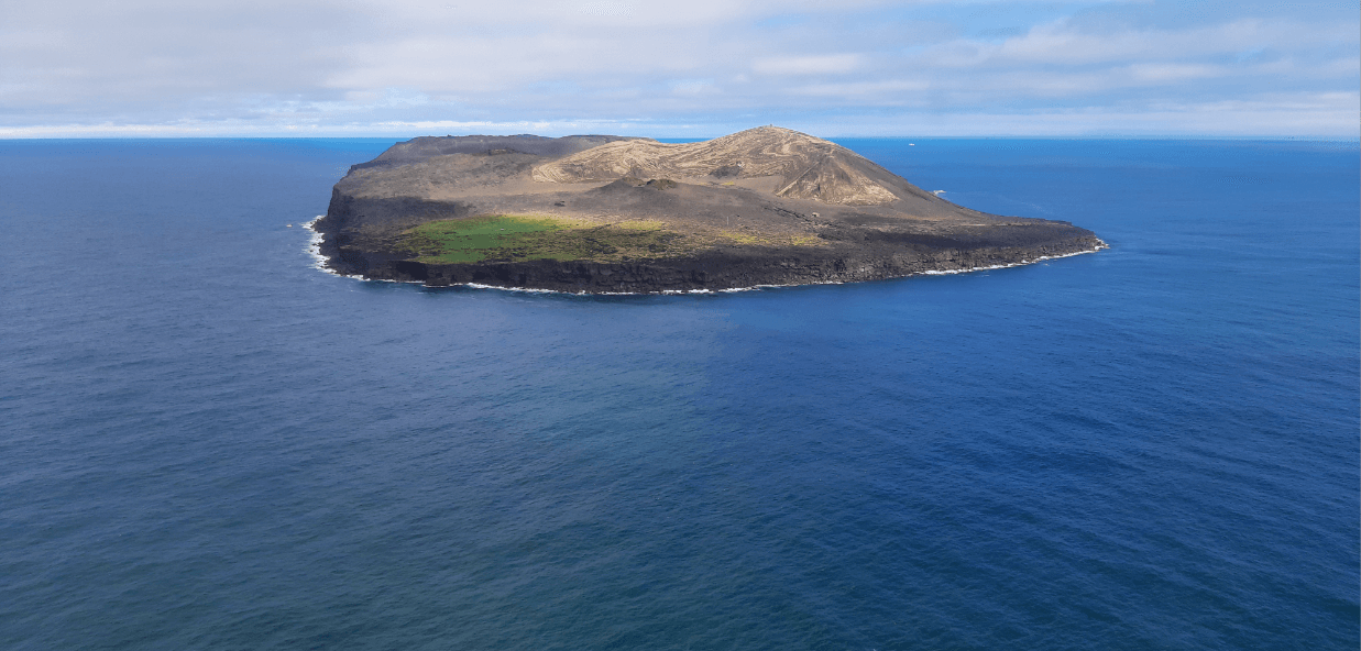 Aerial view of Surtsey showing the volcanic island surrounded by open sea.